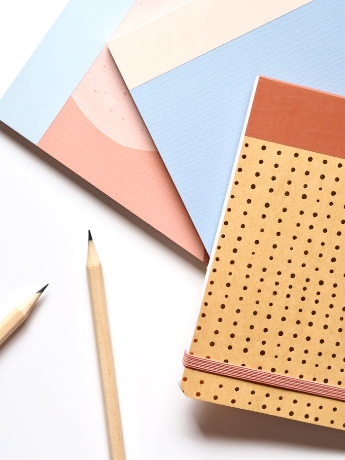 Colorful notebooks and pencils arranged neatly for a creative workspace.